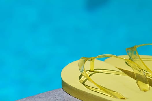 Colored flipflops of a family of four by the swimming pool