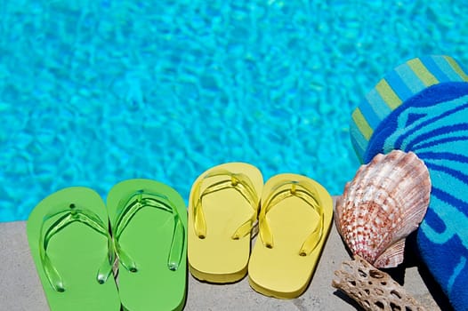 Colored flipflops of a family of four by the swimming pool