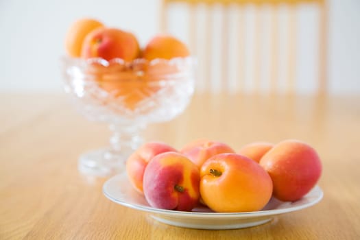 Image of fresh ripe apricots on a plate on dining table