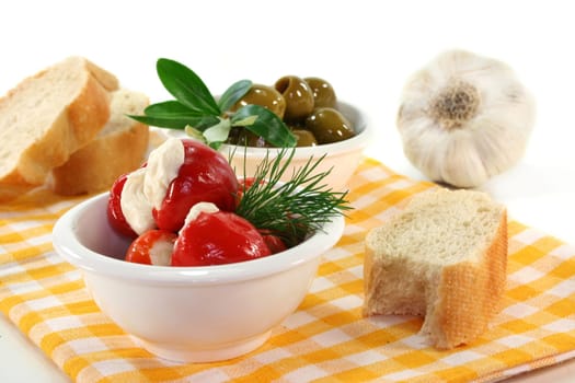 stuffed pepperoni and green olives in white bowls