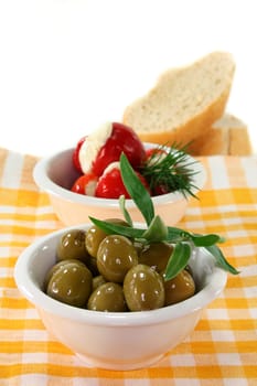 stuffed pepperoni and green olives in white bowls