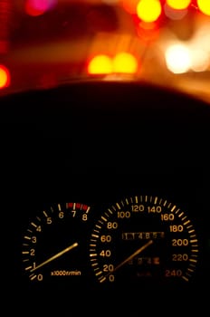 a speedometer showing stop position of a car at night, in traffic jam.