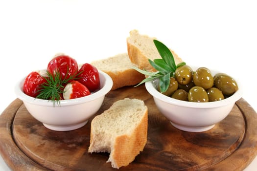 stuffed pepperoni and green olives in white bowls