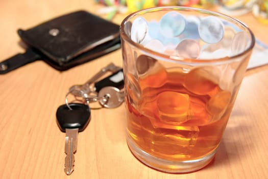 wallet whiskey glass and keys at office party on desk depicting dont drink and drive