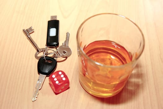 whiskey glass and keys and dice on office desk depicting dont gamble with your life