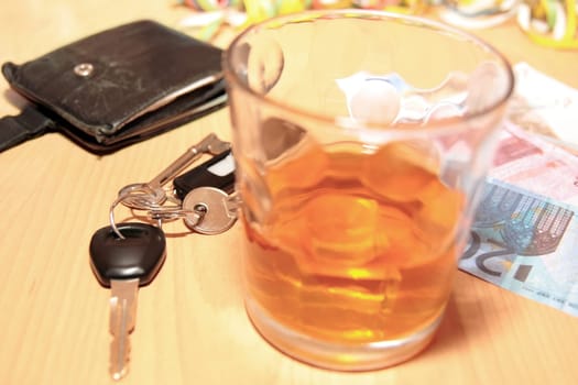 wallet whiskey glass and keys at office party on desk depicting dont drink and drive