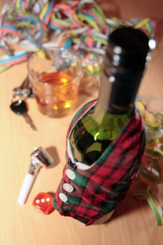 bottle dressed in jacket warmer with car keys on office desk depicting drunk driving and addictions can kill