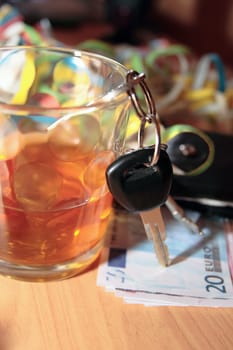 wallet whiskey glass and keys at office party on desk depicting dont drink and drive