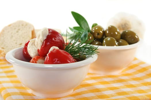 stuffed pepperoni and green olives in white bowls