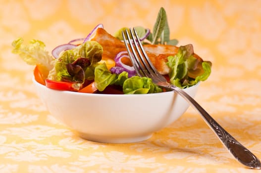 mixed salad with turkey breast on yellow background with pattern