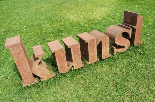 Three-dimensional representation of the word ART on a lawn