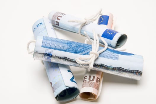 rolled EURO notes tied with string on a light background