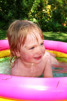 paddling pool in garden with small boy. summer holiday or vacation relaxing