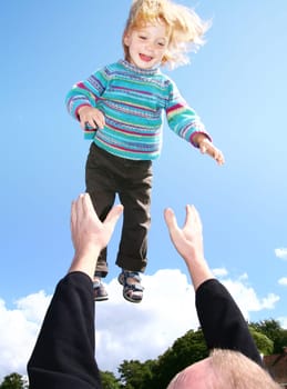 child fly in air. parent throw boy in the sky. playingfamily with laughing toddler
