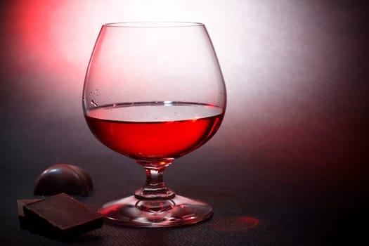 Luxury red liqueur on crystal balloon glass and milk chocolate