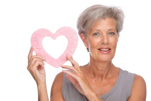 Studio shot of an active senior woman with a pink heart