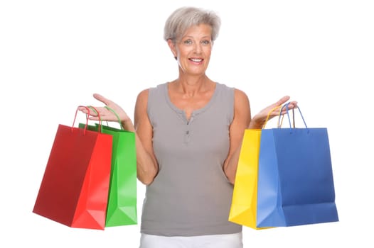 Studio shot of active senior woman with shopping bags