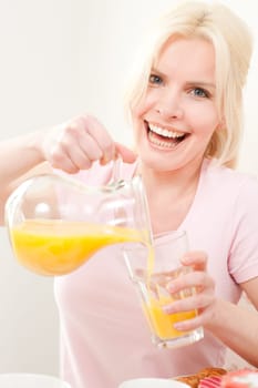 Young and blonde woman sitting at a breakfast table