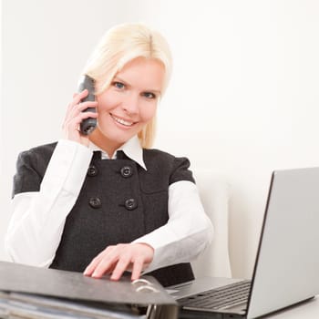 Young businesswoman sitting at desk with computer