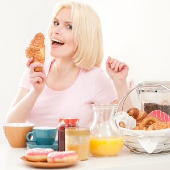 Young and blonde woman sitting at a breakfast table