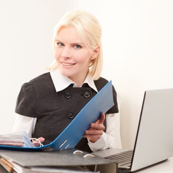 Young businesswoman sitting at desk with computer