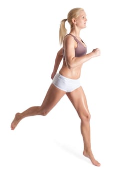 Young woman jogging in front of light background