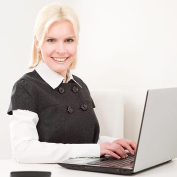 Young businesswoman sitting at desk with computer