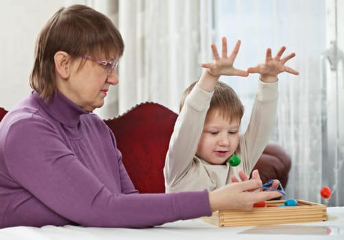 Granny is playing with her grandson at home