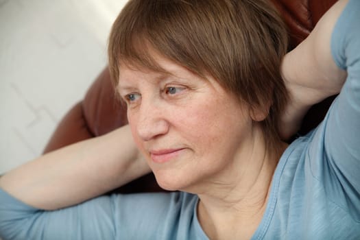 Portrait of a senior woman relaxed in an armchair at home