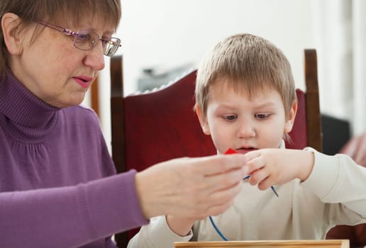 Granny is playing with her grandson at home