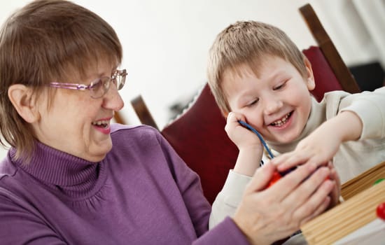 Granny is playing with her grandson at home