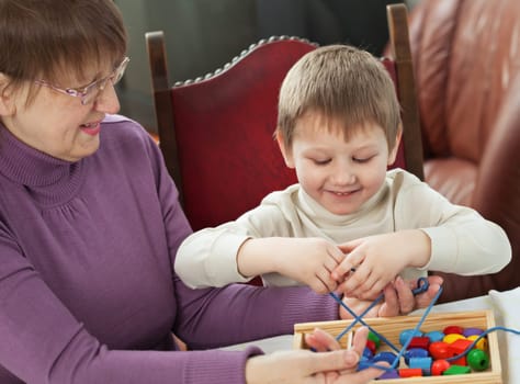 Granny is playing with her grandson at home