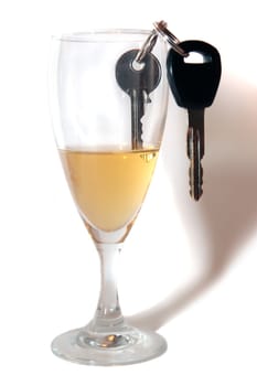 champagne or lager with keys inside glass on white background depicting drunk driving and addictions can kill