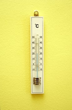 white wooden termometer on the yellow wall
