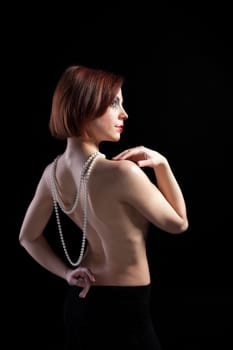 Woman with naked spine and pearl beads - retro style make-up