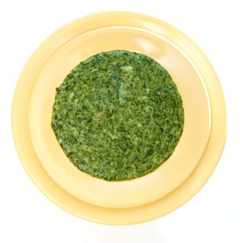 Spinach cream soup in yellow plate
