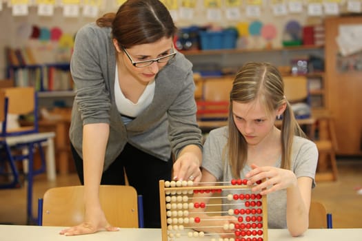 Teacher and students in the elementary school. The teacher told the school child a task