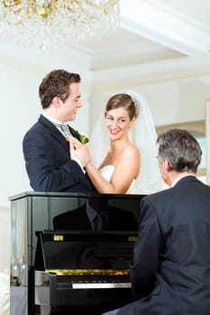 Bride and groom in front of a piano
