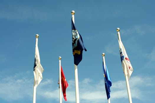 five flags against blue sky with no wind
