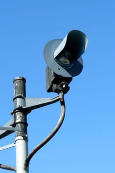 A Railroad signal light against blue sky