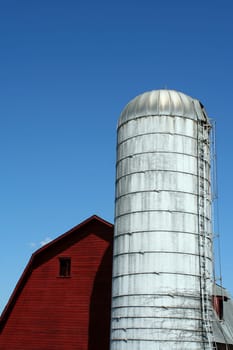 A Red barn and silo against blue sky