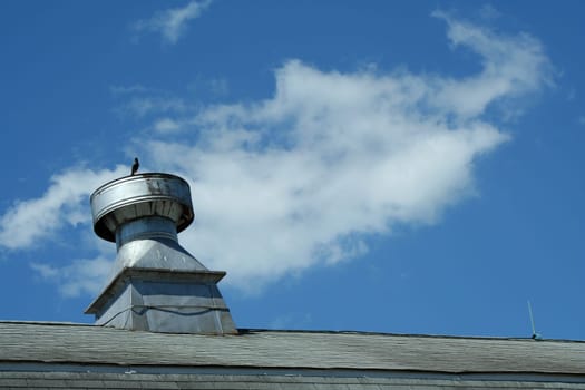 A Barn roof vent against blue sky