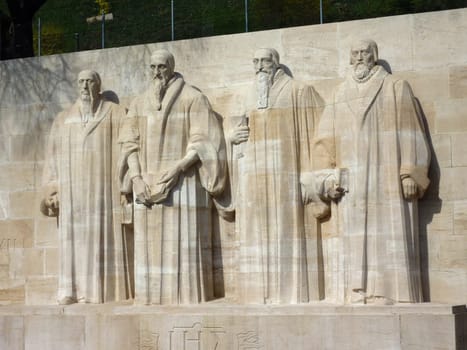 Sculptures of the four great figures of the geneva protestant movement : Guillaume Farel (1489 - 1565), Jean Calvin (1509-1564), Theodore de Beze (1513-1605) and John Knox (1513-1572) on the reformation wall in Bastions park, Geneva, Switzerland. The cons