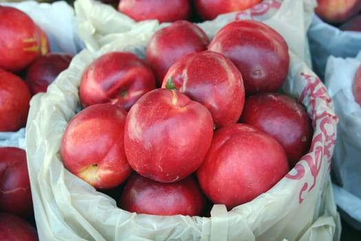 a backet of nectarines for sale at the market