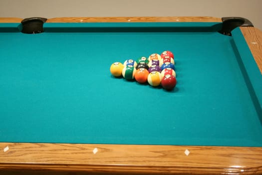 Racked 8 ball game on a green pool table