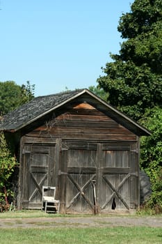 An Old wooden barn with grass and sky