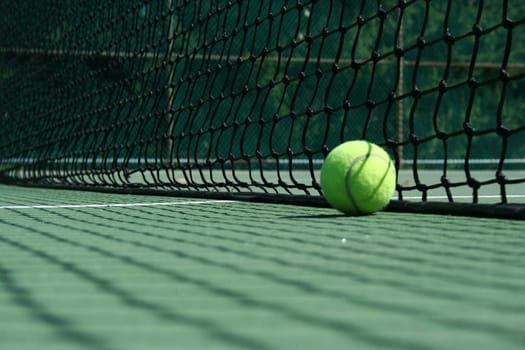 A Tennis ball near net with showdows