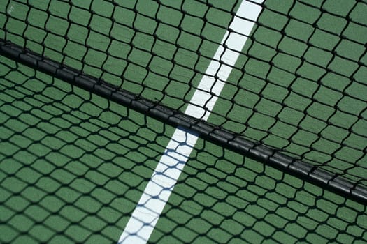 A Tennis net and shadows with white line