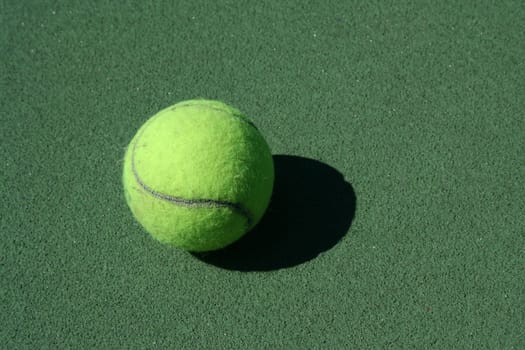 A Tennis ball on a green court