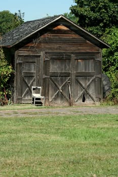 An Old wooden barn with grass and sky